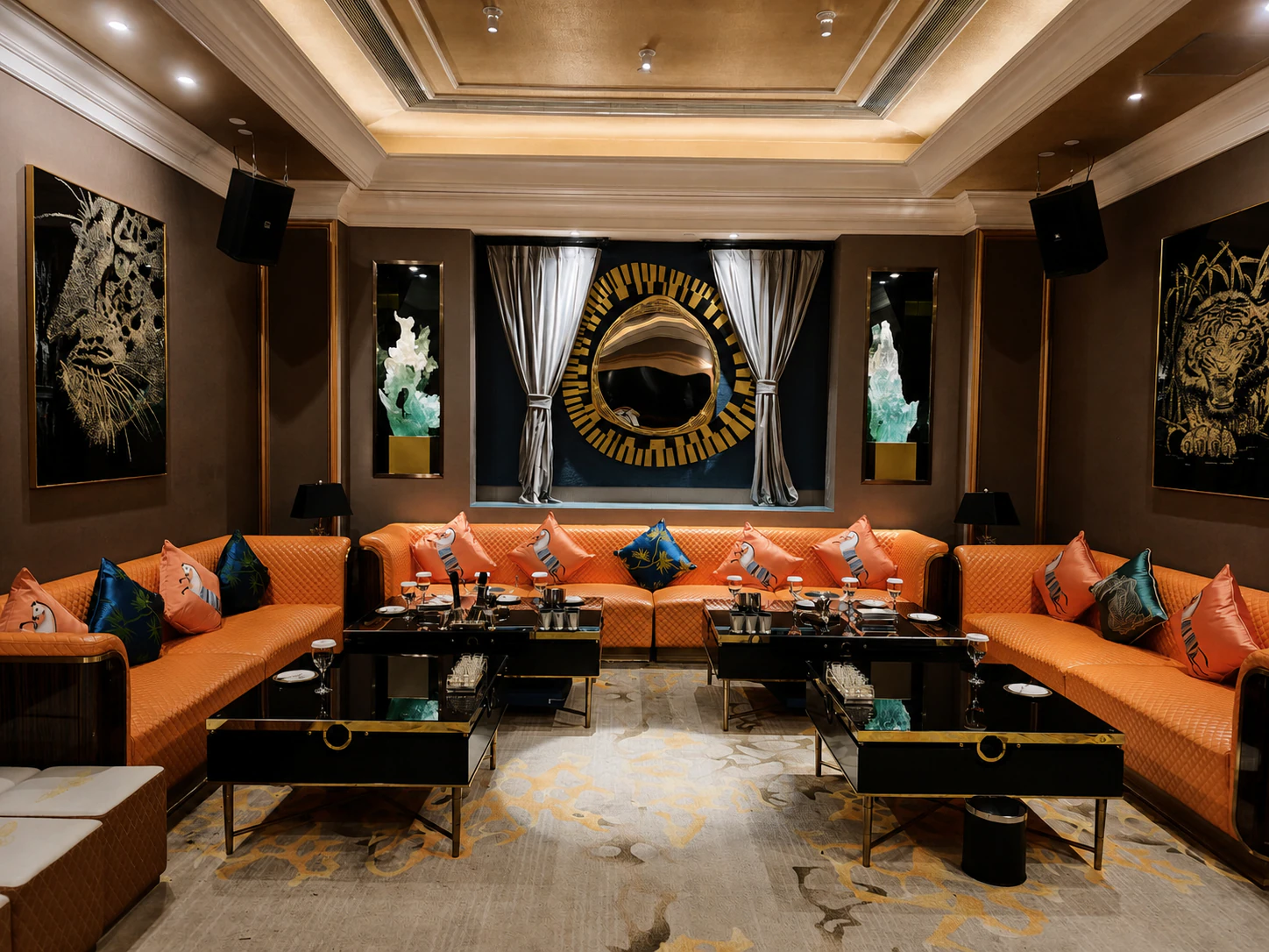 Orange sectional lounge with black tables and gold wall art