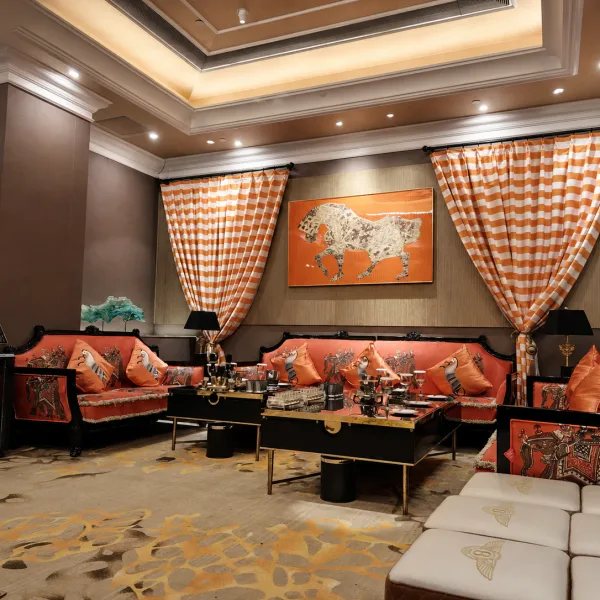 Spacious lounge with patterned red sofas and horse artwork