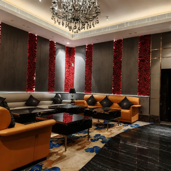Chandelier lounge with red feature panels and tan seating