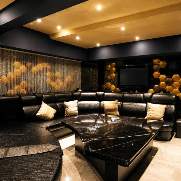 Black sectional lounge with gold honeycomb wall art