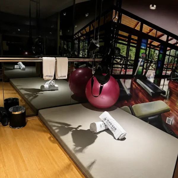 Mirrored room with two padded tables and red exercise ball