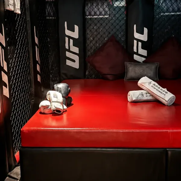 Red padded bed in a black combat-sports themed room