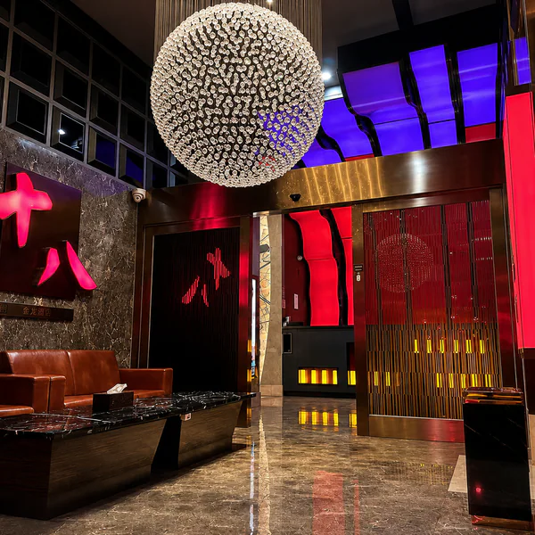 Red-and-black entrance lounge with leather sofas and a crystal chandelier