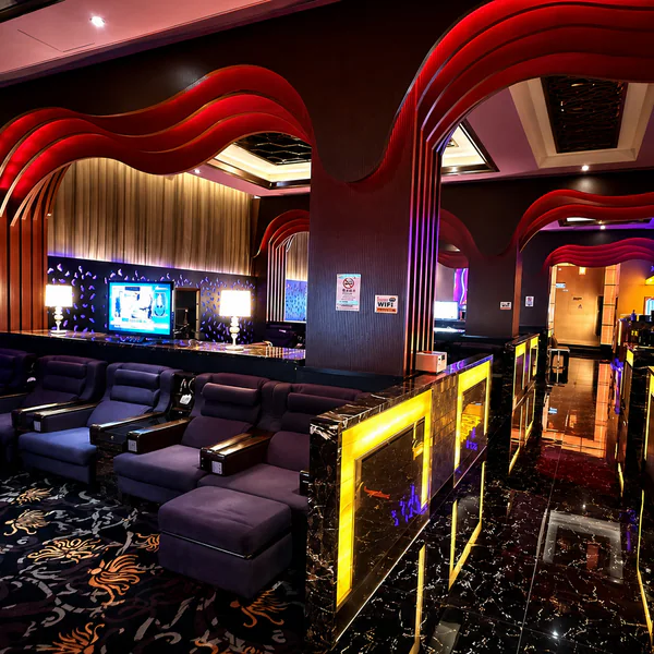 Dark recliner lounge with curved red ceiling details