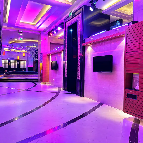 Purple corridor leading toward a circular bathing pool
