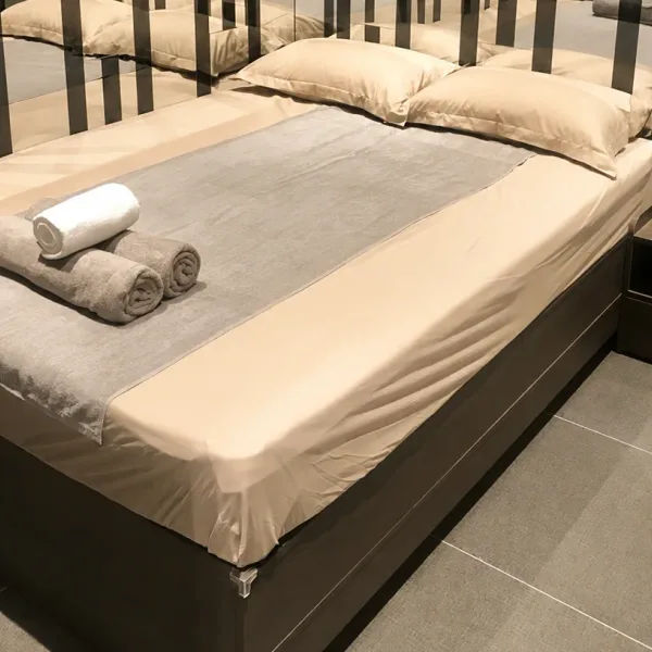 Grey double bed with striped feature wall