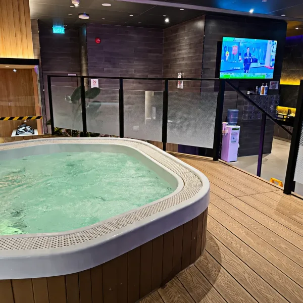 Oval whirlpool tub in a wood-floored bathing area