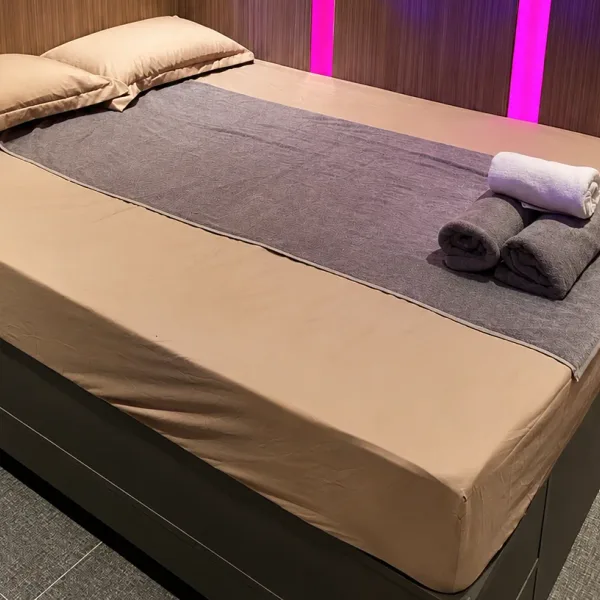 Double bed with grey runner and vertical pink lights