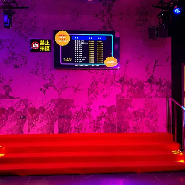 Red bench beneath a wall-mounted digital display