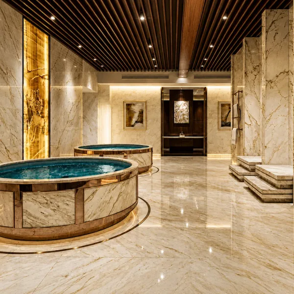 Circular mosaic pool in a cream marble bathing room
