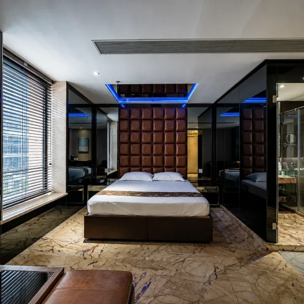 Hotel-style bedroom with blue ceiling accent and glass bathroom