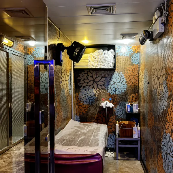 Compact treatment room with floral wall and television