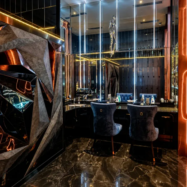 Black marble vanity with tall mirrors and warm light strips