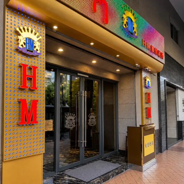 Street entrance with gold trim and vertical HM sign