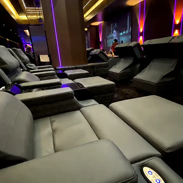 Row of black reclining chairs in a neon lounge