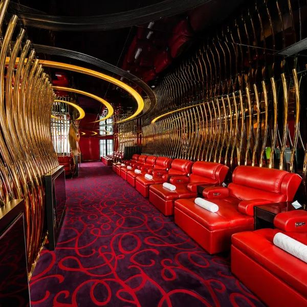 Row of red recliners beside a curved gold partition