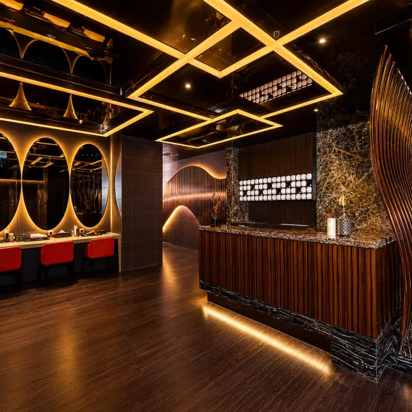 Wood counter and round mirrors under geometric gold lighting