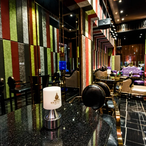 Long lounge with multicoloured wall panels and black tables