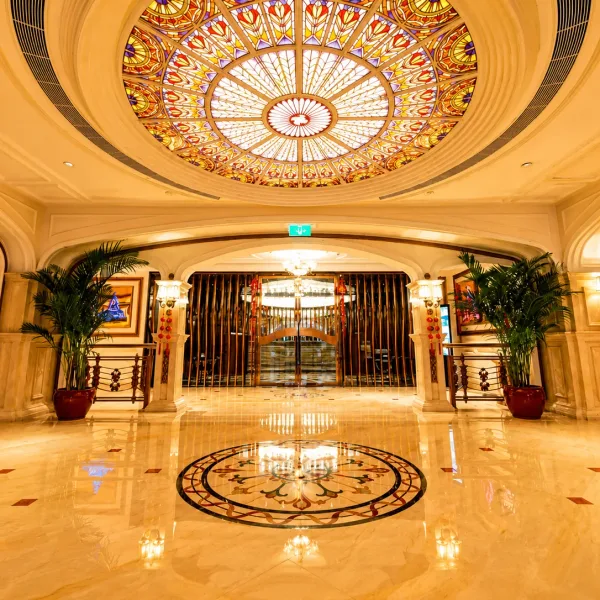 Marble hotel lobby beneath a stained-glass dome