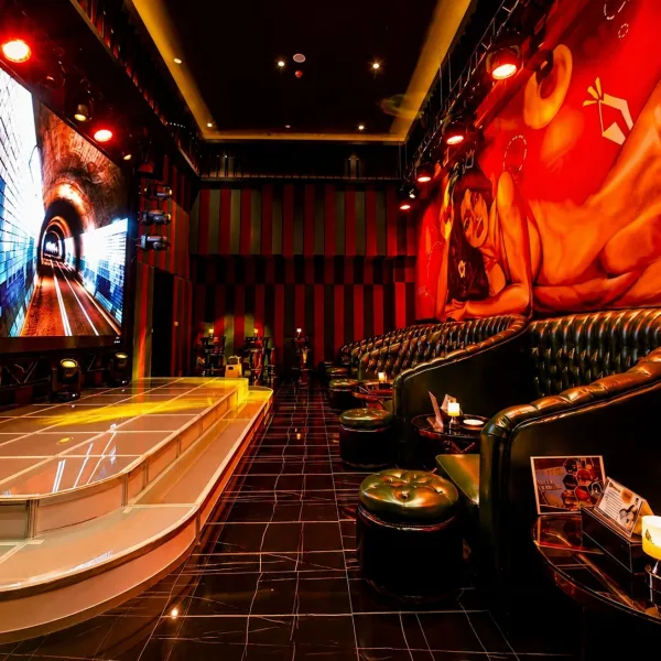 Wide stage with giant screen and dark lounge seating