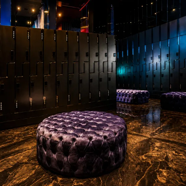 Black locker room with purple tufted ottomans