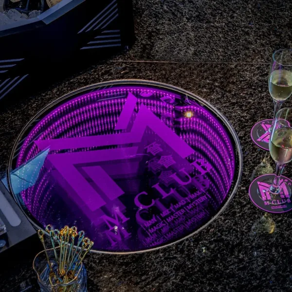 Purple illuminated logo table with champagne glasses