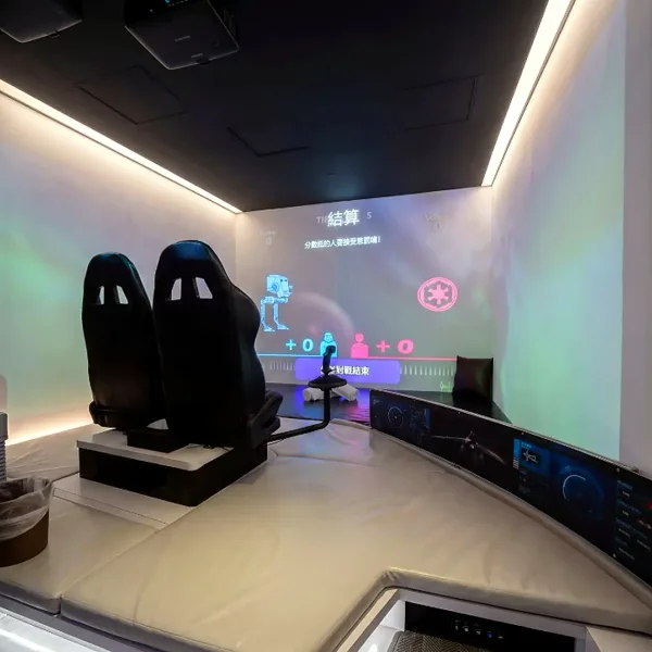 Two gaming chairs facing a wall-sized projection