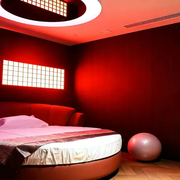 Red bedroom with round bed and circular ceiling light