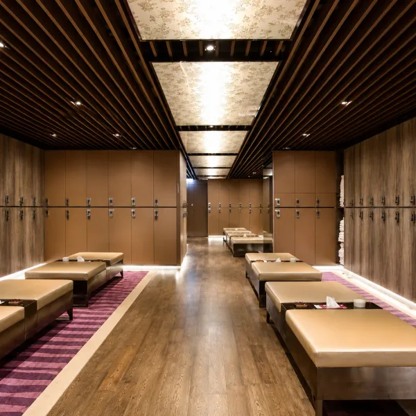 Long wood-panelled room with parallel padded tables