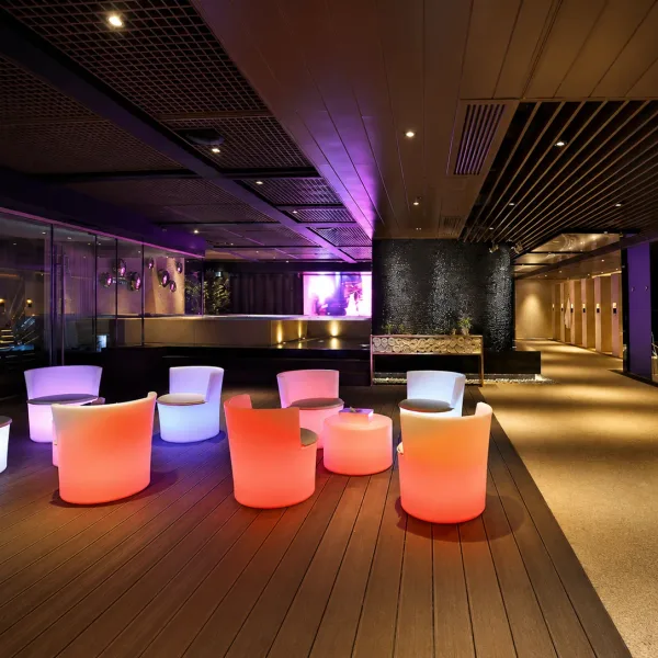 Modern lounge with glowing white and orange barrel chairs