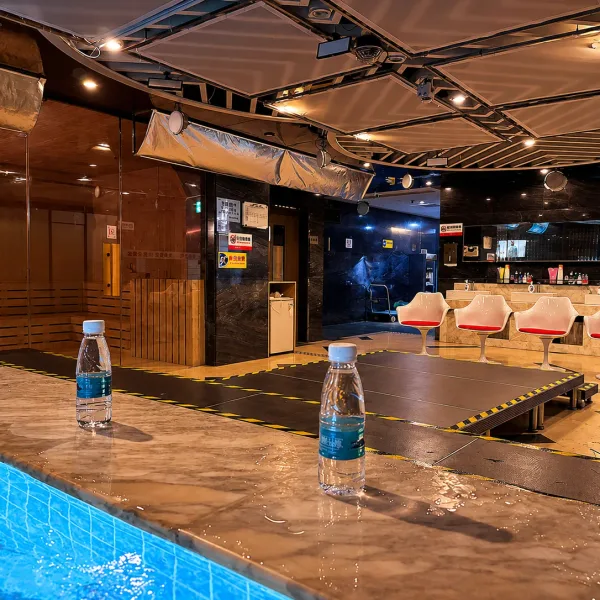 Long stone table beside a blue indoor pool