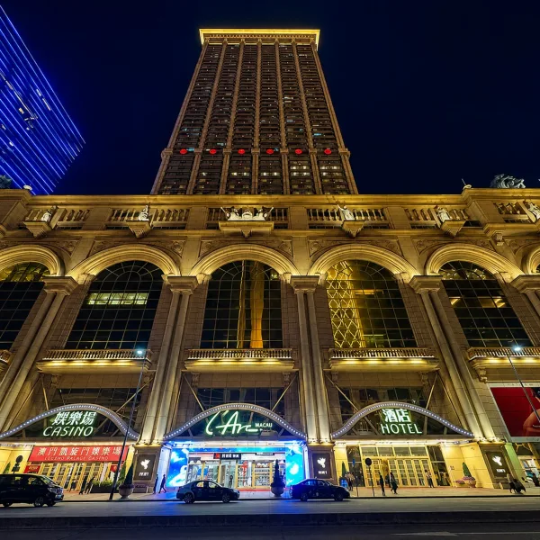 Grand arched hotel façade viewed from below at night